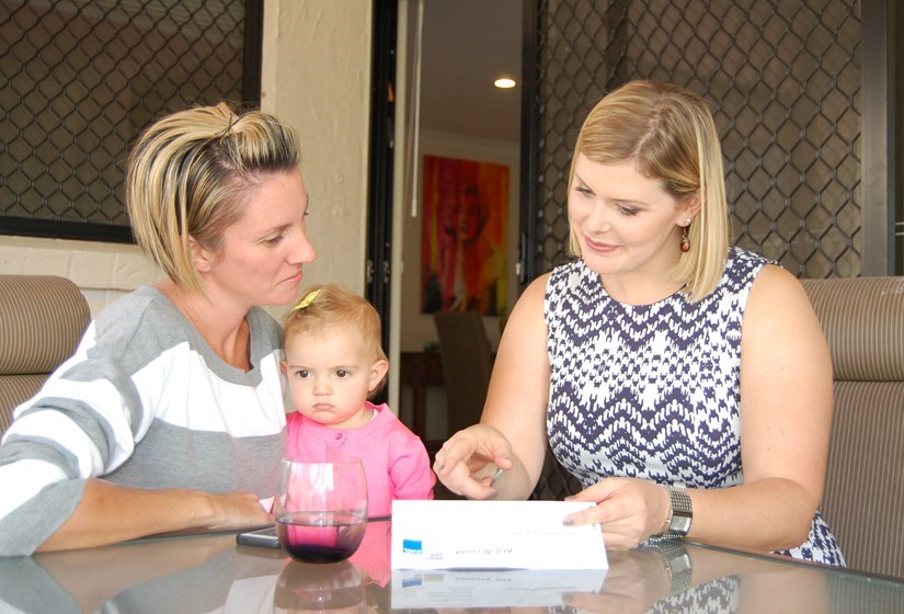 image of Nikki Boyd sitting with a family looking at a power bill